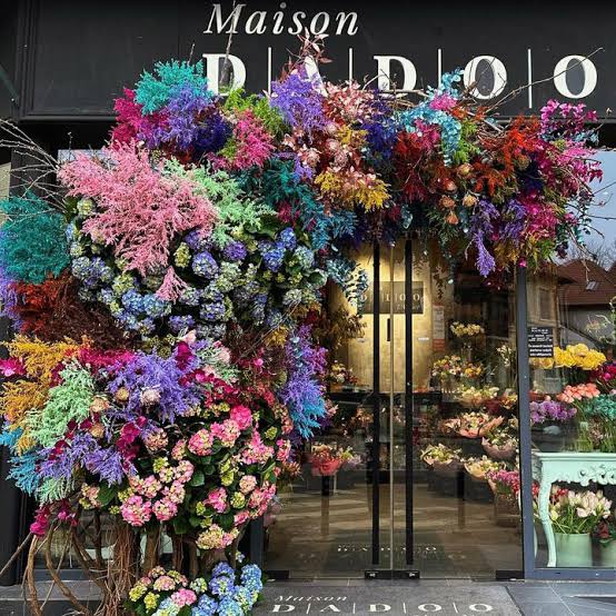 Maison DADOO storefront with a floral installation