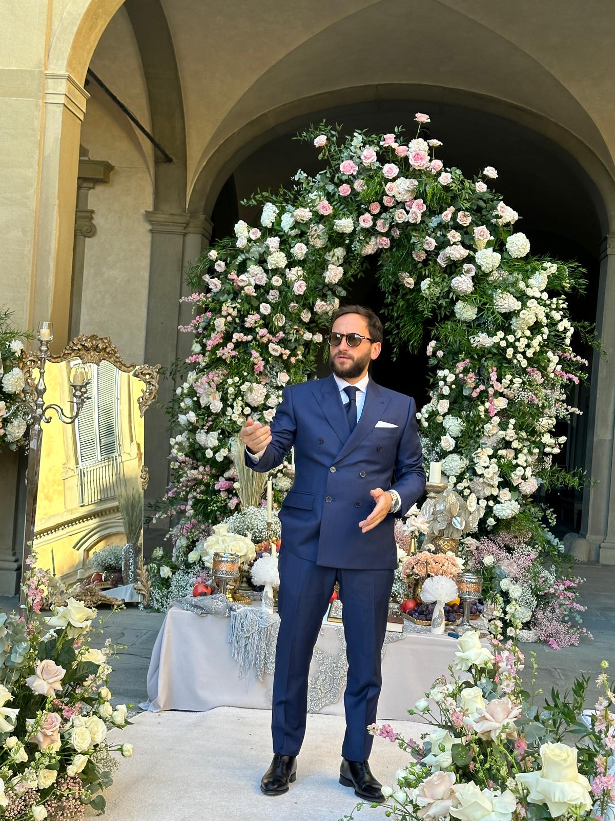 Alexandru Dadoo in front of a floral arch